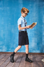 Boy wearing a blue short-sleeve summer casual button-up shirt with front pocket by Everanne.