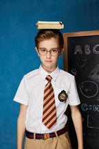 Boy wearing a white short-sleeve summer button-up shirt with front pocket by Everanne, casual boys' tops for warm weather.