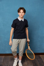 Unisex kids navy polo shirt by Everanne, short sleeve pique mesh cotton blend T-shirt displayed on a child.
