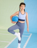 A young girl wearing the Everanne seamless racerback sports crop top during active sports practice.
