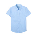 Boy wearing a blue short-sleeve summer button-up shirt with front pocket by Everanne, casual casual tops for boys.